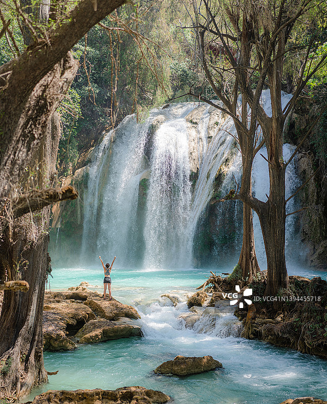 在恰帕斯州埃尔奇夫隆瀑布附近举起双臂的女人图片素材