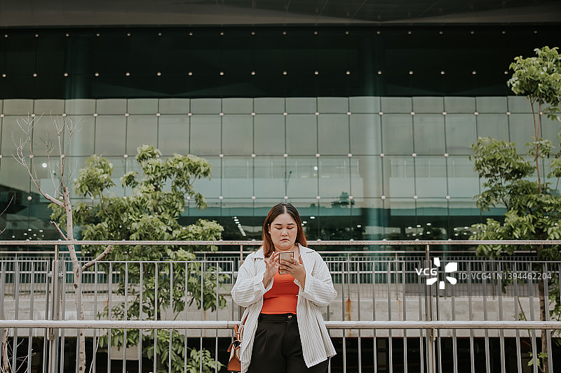 下班後與朋友在線發短信的年輕亞洲女商人图片素材