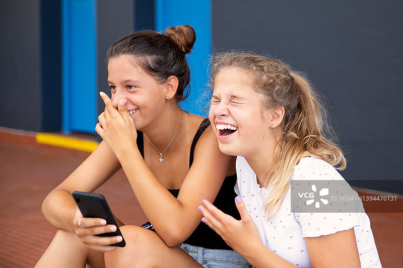 用手机看视频的两位少女图片素材