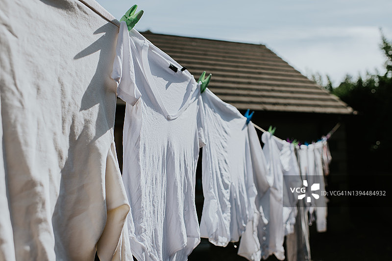 晾衣绳上晾晒的一排白色衣物图片素材