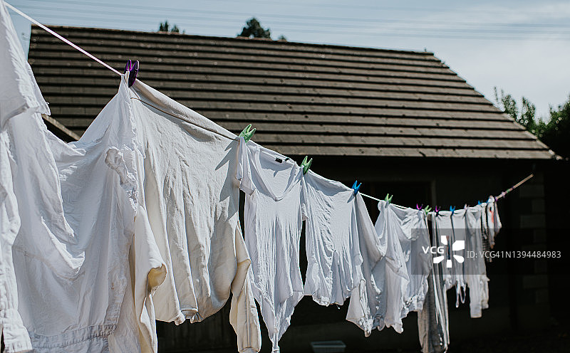 晾衣绳上晾晒的一排白色衣物图片素材