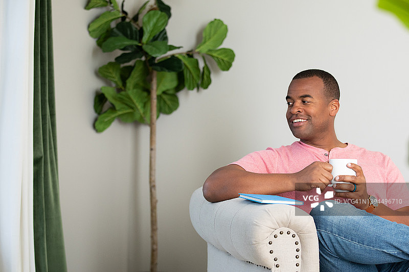 中年男人在家放松地在沙发上享受早晨咖啡图片素材