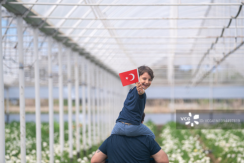 父亲扛着儿子，儿子肩上扛着土耳其国旗的照片图片素材