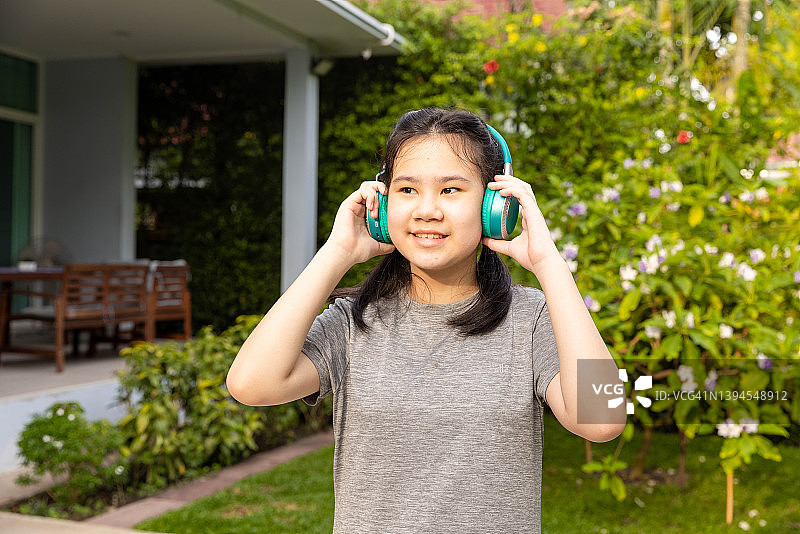 年轻女孩在房子前做步行运动图片素材