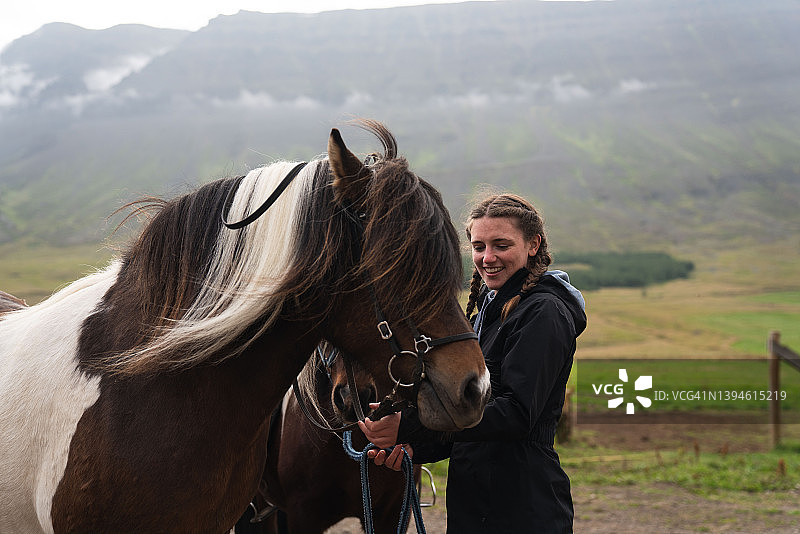 年轻女子牵着冰岛马去牧场图片素材