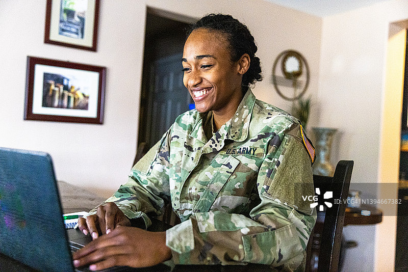 在家中使用笔记本电脑的年轻黑人美国士兵图片素材