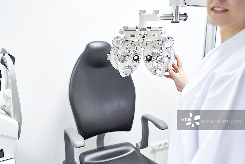 漂亮的女眼科医生在预约前检查屈光仪图片素材