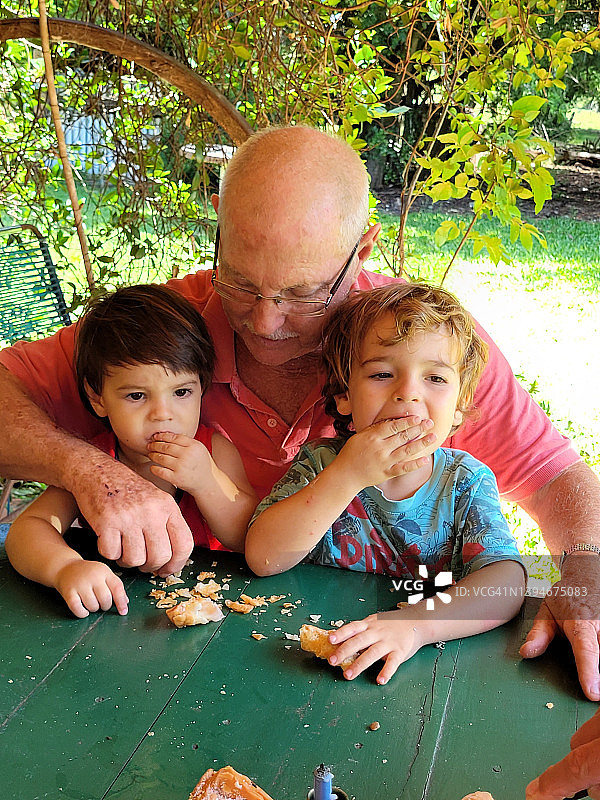 爷爷和孙子孙女一起吃蛋糕图片素材