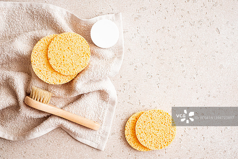 混凝土背景上的环保面部、头发和身体护理必需品套装（木制身体刷、清洁手套、清洁海绵、发刷、喷雾、保湿霜）。家庭水疗，平铺。零浪费理念。图片素材