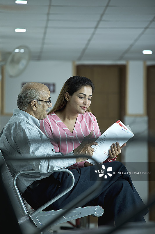 女儿在医院分析老父亲的检查结果图片素材