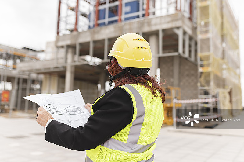 中年女建筑师在查看房屋建造计划图片素材