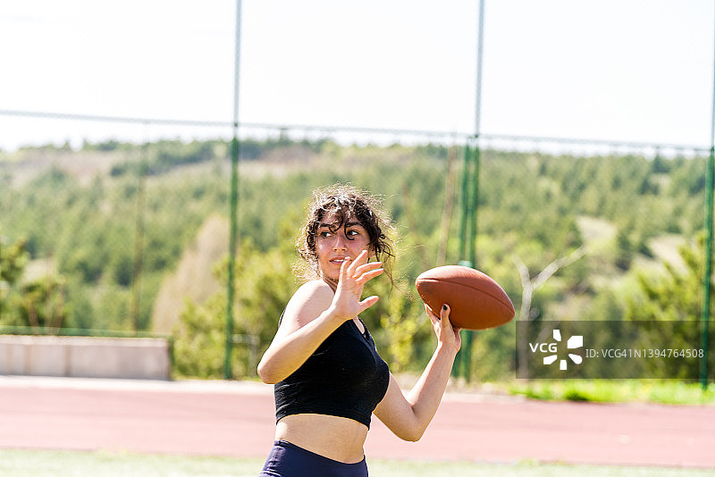 在球场上手持足球的年轻女子肖像图片素材