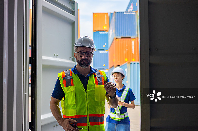 两名仓库工人在货运场打开空的集装箱图片素材