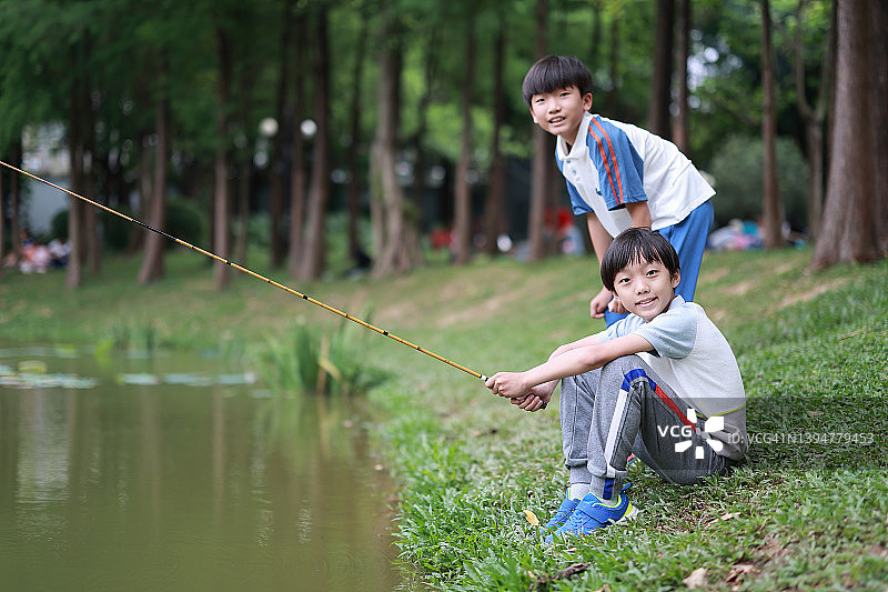 小男孩在湖边钓鱼图片素材