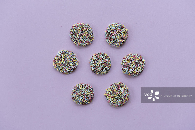 紫色背景上的巧克力雀斑糖果六边形图案图片素材