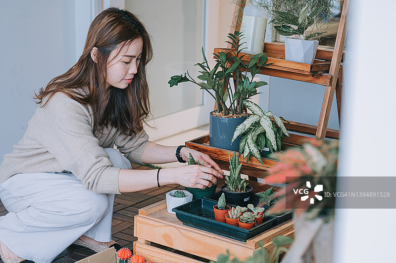 亚洲华人女花店老板在店外整理花束，准备开店图片素材