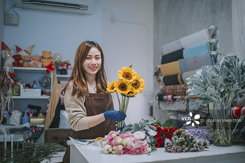 自豪的中国女花艺师在花店微笑图片素材