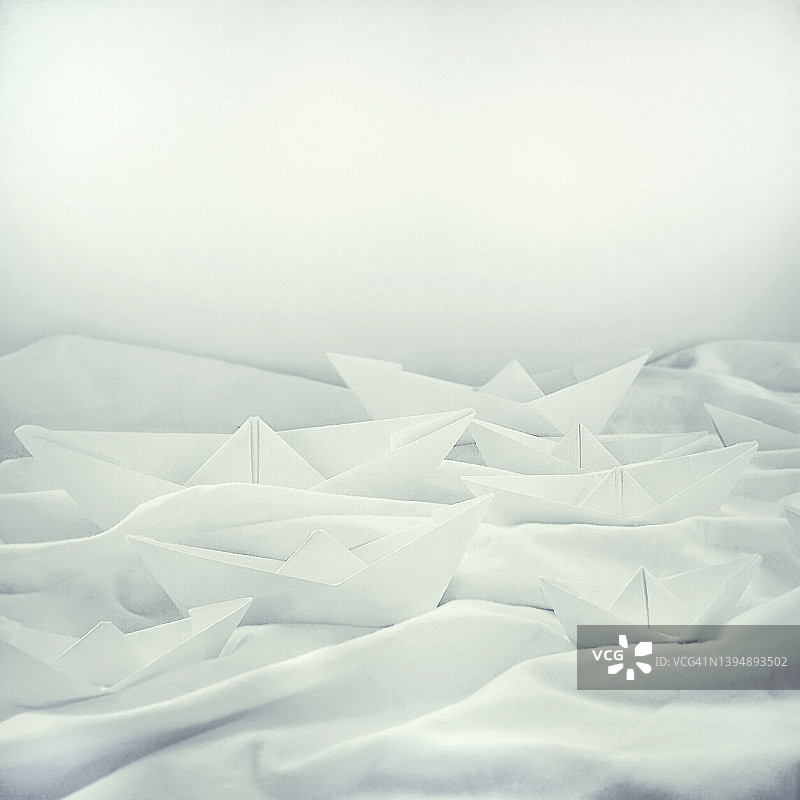 白色纸船玩具静物（海浪背景，特写，选择性聚焦）图片素材