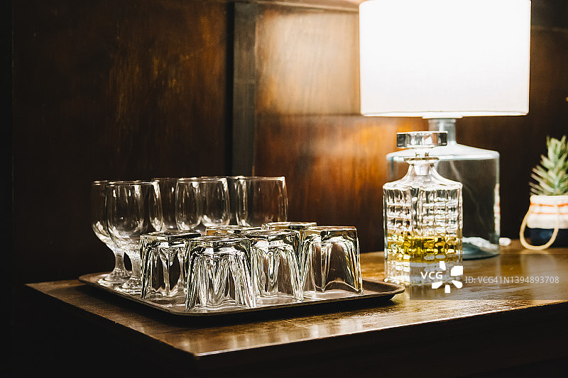 木制吧台上复古威士忌酒瓶和酒杯图片素材