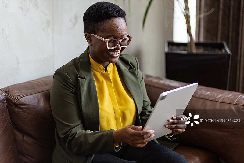 快乐的年轻黑人女商人正在看平板电脑图片素材