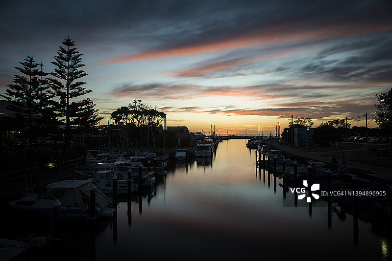 澳大利亚墨尔本码头，船只倒映着彩色日落图片素材