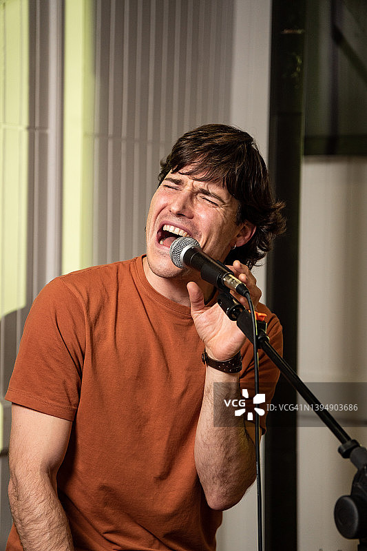 年轻男人在酒吧演唱卡拉OK图片素材