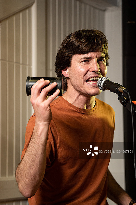 在酒吧音乐会上唱歌的歌手肖像，有色光照明图片素材