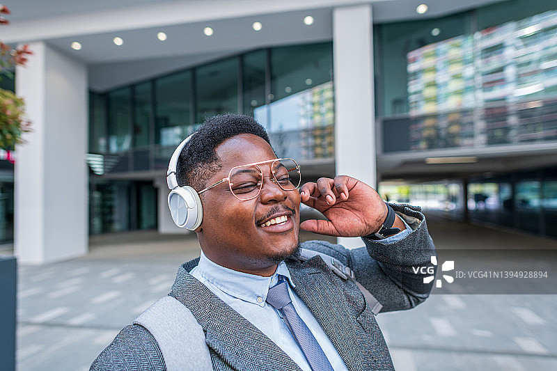 在上班路上听音乐的快乐年轻优雅男士图片素材