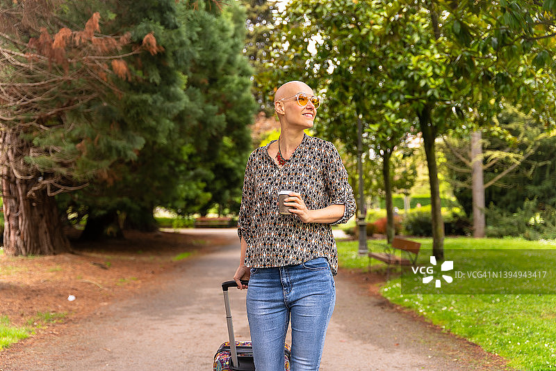 一位患乳腺癌后在公园里享受生活的地中海秃顶妇女图片素材