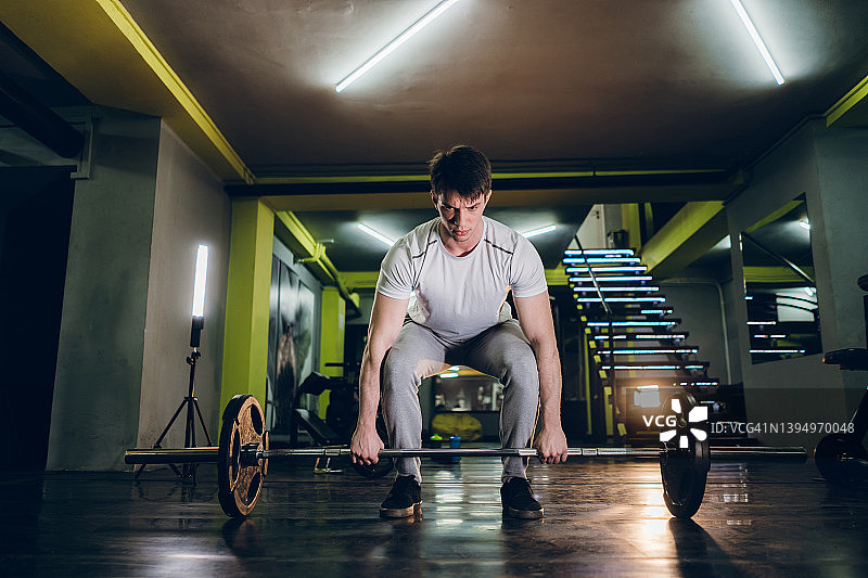健身房中专注举杠铃的男人图片素材