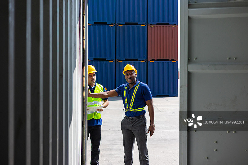 两位戴头盔的集装箱工头检查货物图片素材