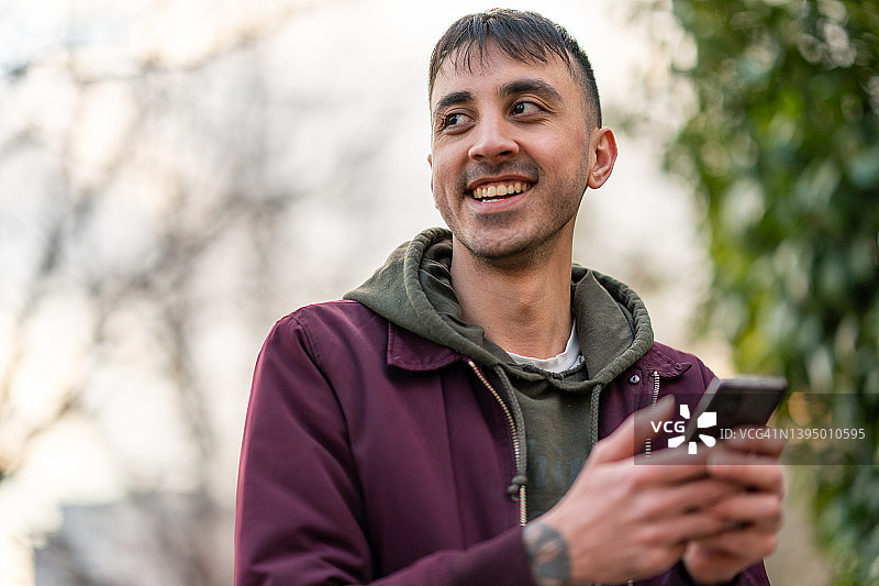 年轻男人在城市里使用手机图片素材