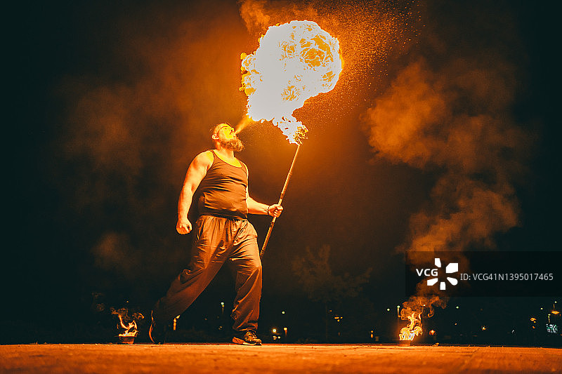 男性喷火表演者喷出巨大的火焰图片素材