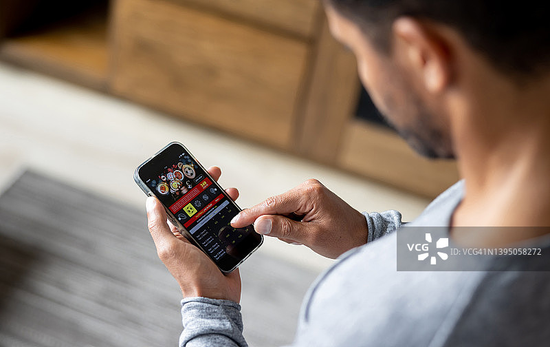 男子用手机在线赌足球比赛图片素材