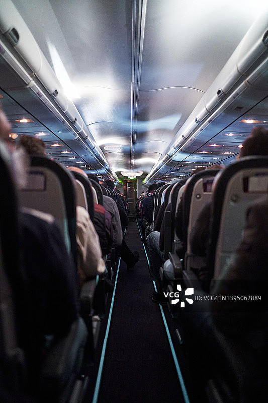 飞行期间坐在飞机舱内的匿名乘客图片素材