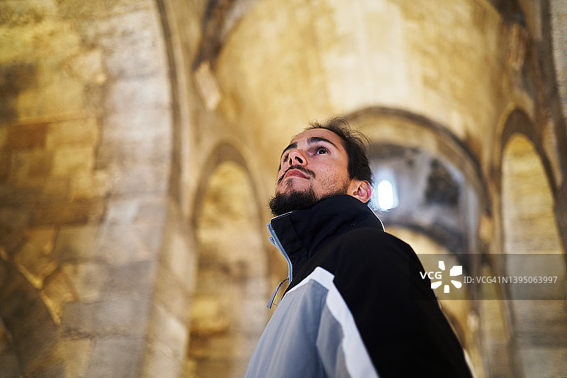 欣赏古老清真寺建筑的严肃的西班牙裔男子图片素材
