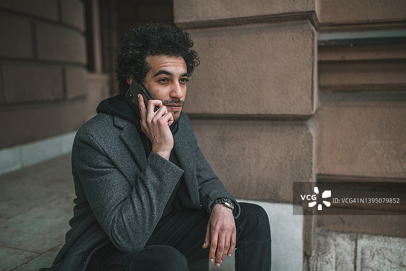 在楼梯上打电话的年轻人图片素材