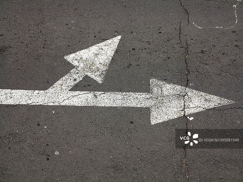 丰沙尔街道上彩绘的、风化的白色箭头图片素材