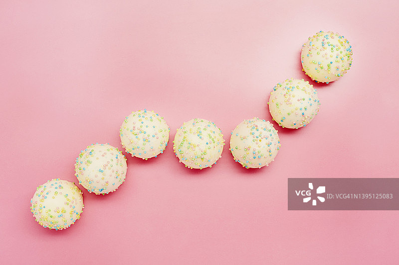 粉色背景上糖果排列成股市曲线的高角度视图图片素材