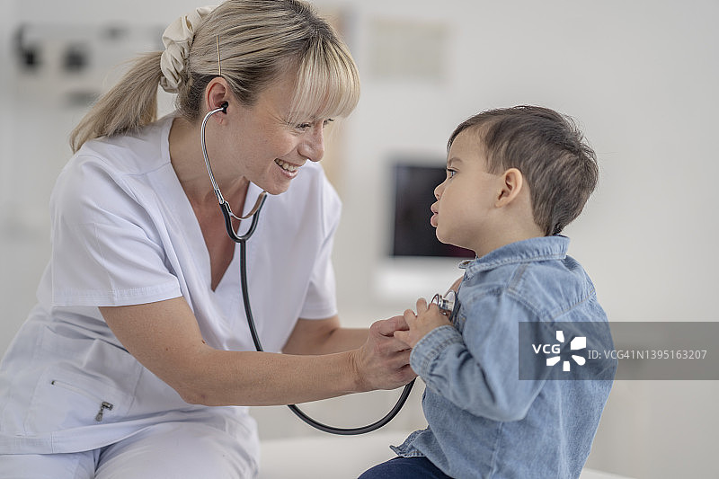 医生正在听小男孩的心跳图片素材