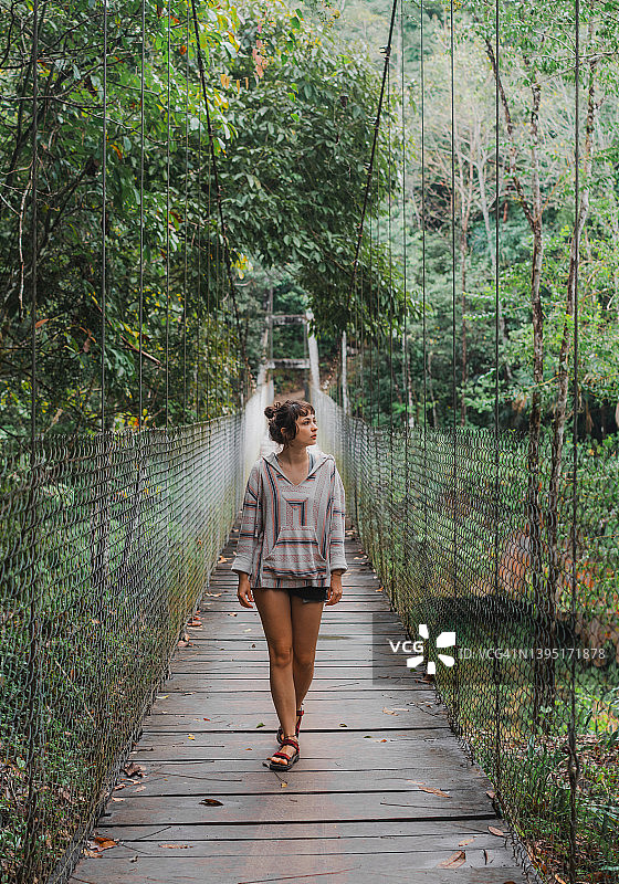 在恰帕斯拉斯努布斯瀑布上方的吊桥上行走的女人图片素材