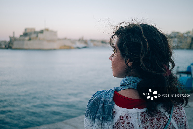 年轻女人在防波堤边看向远方图片素材