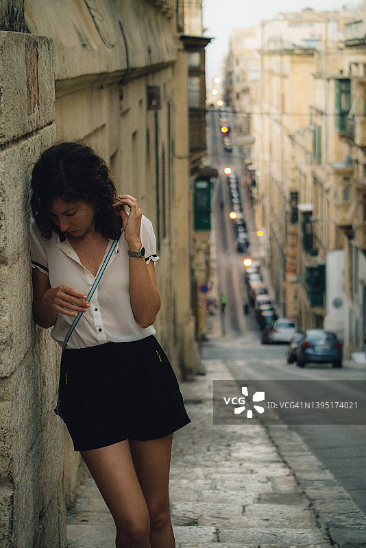 在老城区街道上怀旧的沉思女人图片素材