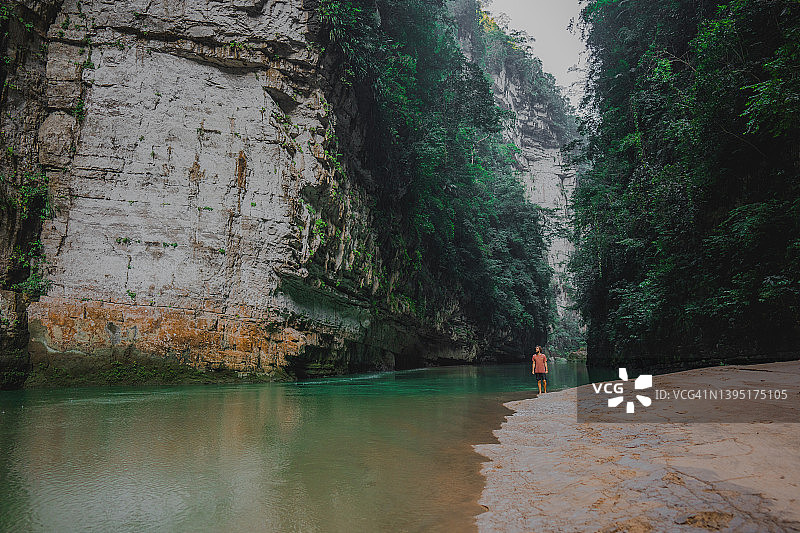 男子在墨西哥绿松石色河流附近行走图片素材