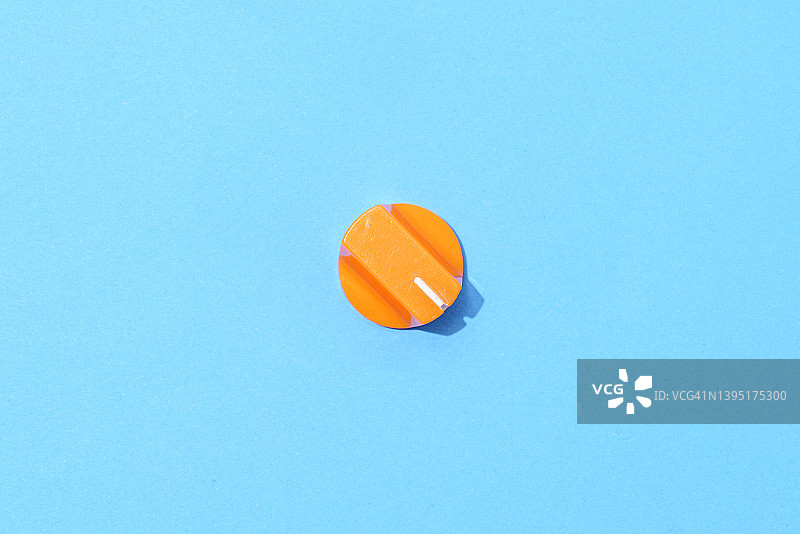 蓝色背景上的橙色塑料旋钮图片素材