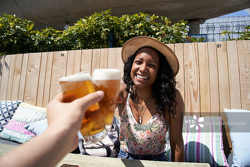 在户外餐厅与男友敬酒的快乐年轻女士肖像图片素材