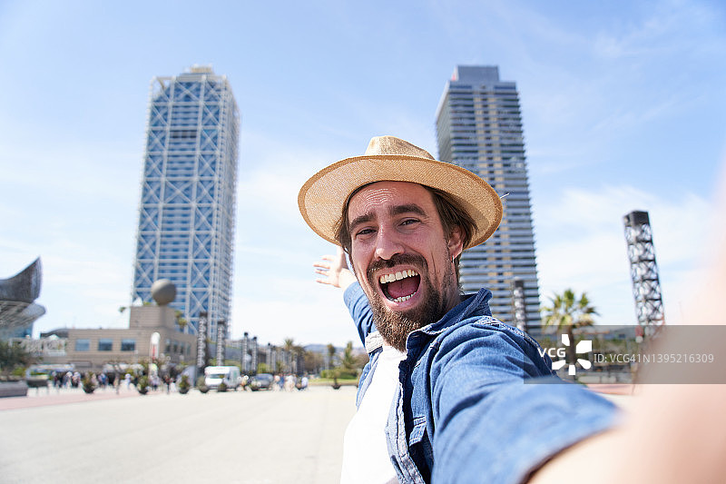 快乐的白人年轻男子自拍，看着镜头展示他的视野图片素材