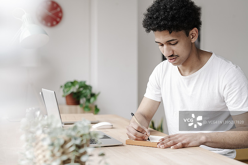 年轻人在家写购物清单图片素材