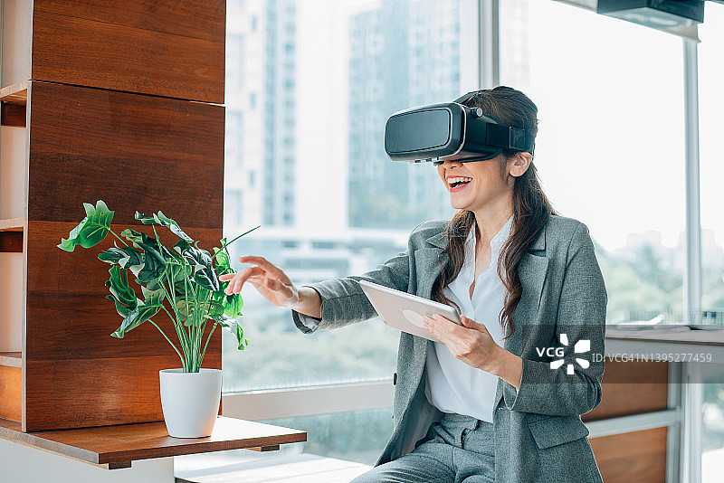 亚洲女商人在现代办公室体验VR头显图片素材