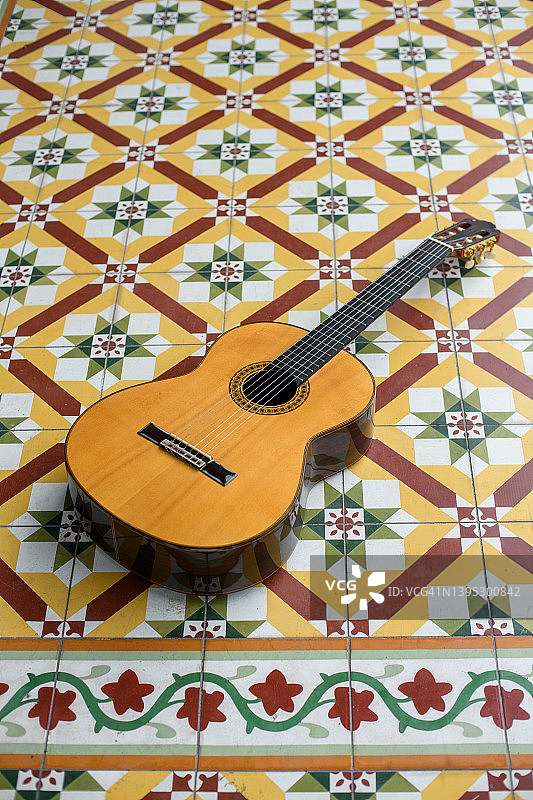 复古瓷砖地板上的古典吉他图片素材